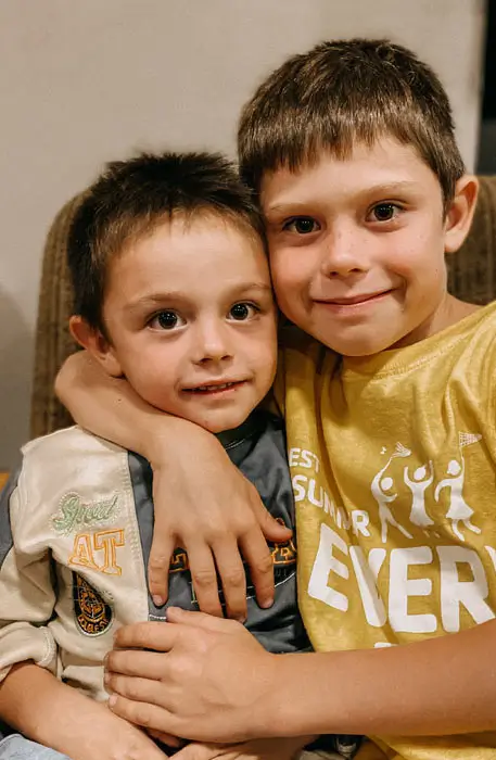 DEICHMANN Stiftung | Einsatz gegen Kinderarmut – Familienzentrum  – Stern im Norden – Freunde treffen - unbeschwert spielen Einsatz gegen Kinderarmut – zwei Freunde Arm in Arm im Familienzentrum Stern im Norden