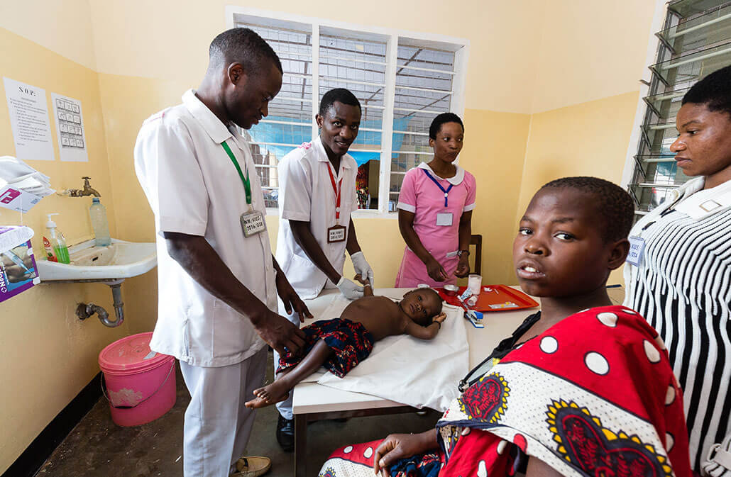 deichmann-stiftung-projekt-Gesundheit-Tansania-Kiuma-Hospital Krankenpflegepersonal untersucht ein kleines Kind