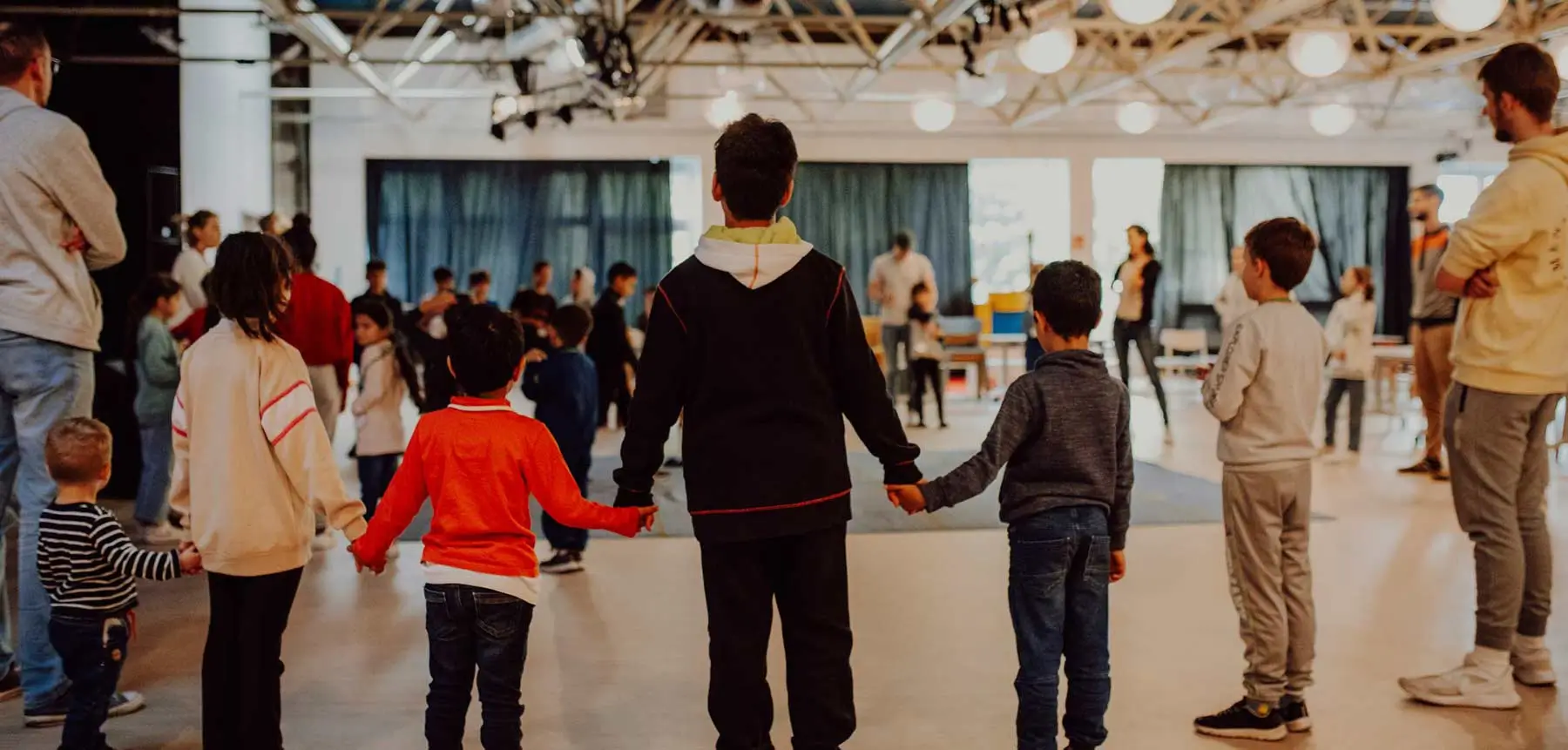 DEICHMANN Stiftung | Einsatz gegen Kinderarmut – Teilhabe – Stern im Norden – Talente entdecken Einsatz gegen Kinderarmut – Kinder spielen und halten sich an den Händen im Familienzentrum Stern im Norden.