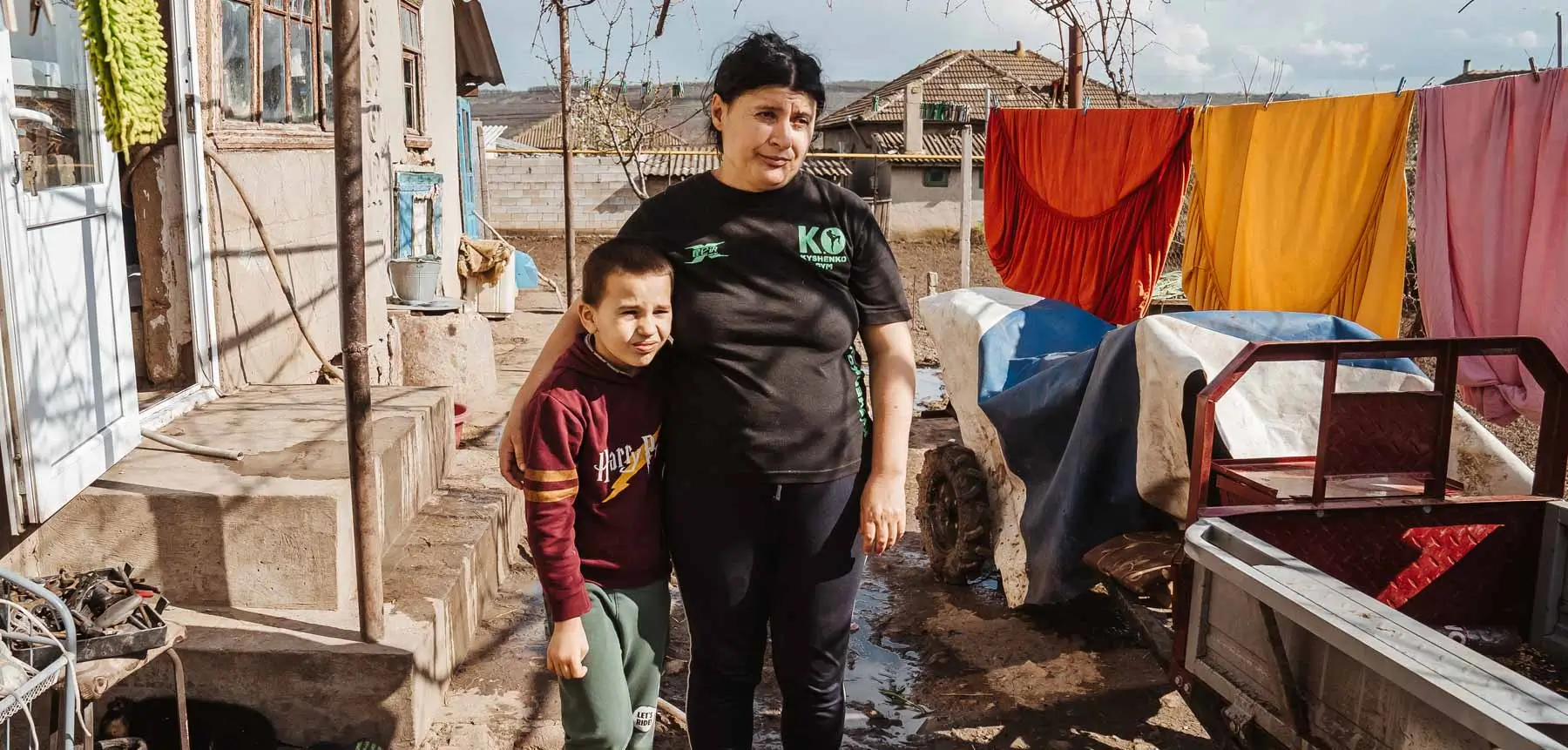 DEICHMANN-Stiftung | Kindern Chancen geben – Kinderarmut in der Republik Moldau – Junge mit Großmutter. Potenziale fördern. Teilhabe ermöglichen. Kindern Chancen geben – Junge sitzt mit seiner Großmutter in einem ärmlichen Haus in der Republik Moldau.