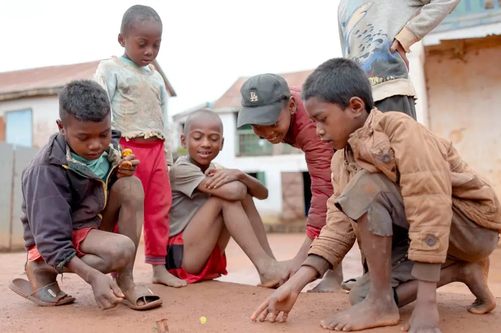 DEICHMANN-Stiftung | Kindern Chancen geben – Kinderarmut weltweit – Kinder spielen auf der Straße in einem Projekt auf Madagaskar – Hoffnung trotz Armut Kindern Chancen geben – Kinder spielen auf einem staubigen Platz in Madagaskar – Kind gerechte Räume schaffen. Chancen auf gesunde Entwicklung geben.